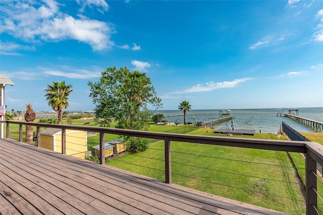 wooden deck featuring a boat dock, a yard, and a water view