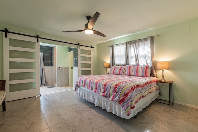 bedroom featuring ceiling fan, a barn door, and a textured ceiling