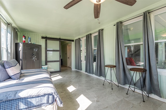 bedroom with a barn door and ceiling fan