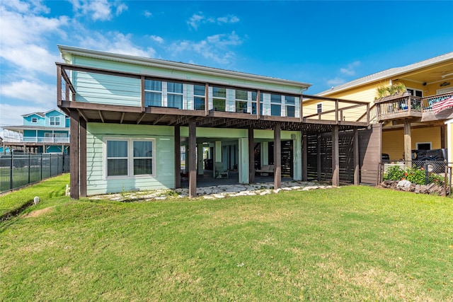 rear view of property featuring a yard, a patio, and a deck