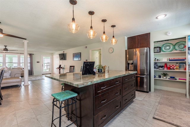 kitchen featuring decorative columns, a breakfast bar, pendant lighting, and stainless steel refrigerator with ice dispenser