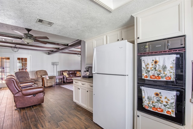 kitchen with white refrigerator, white cabinets, dark wood-type flooring, beamed ceiling, and ceiling fan