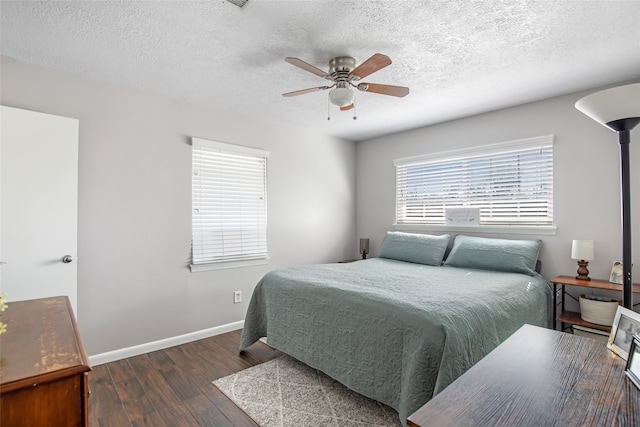 bedroom with a textured ceiling, dark hardwood / wood-style floors, and ceiling fan