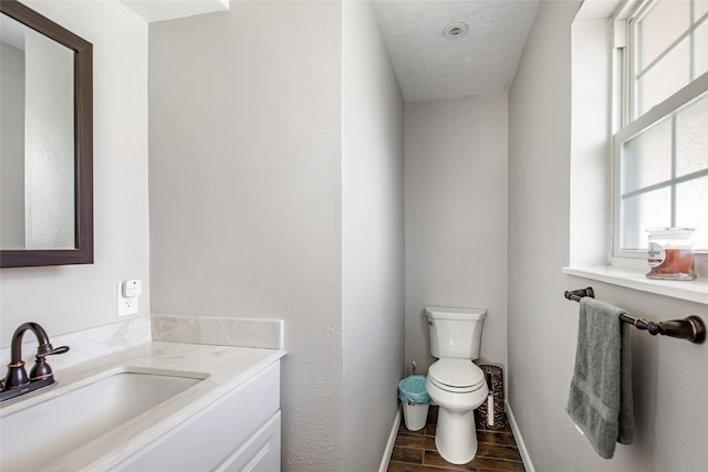 bathroom featuring hardwood / wood-style floors, vanity, toilet, and a textured ceiling