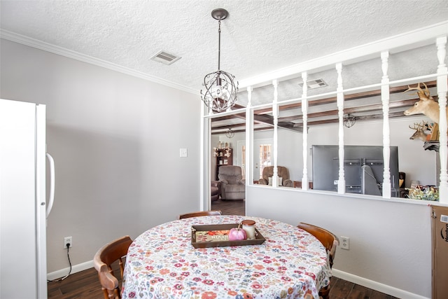 dining space featuring dark hardwood / wood-style floors, a textured ceiling, and crown molding