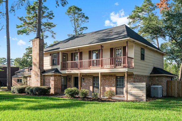 view of front of house with central AC unit, a balcony, and a front lawn