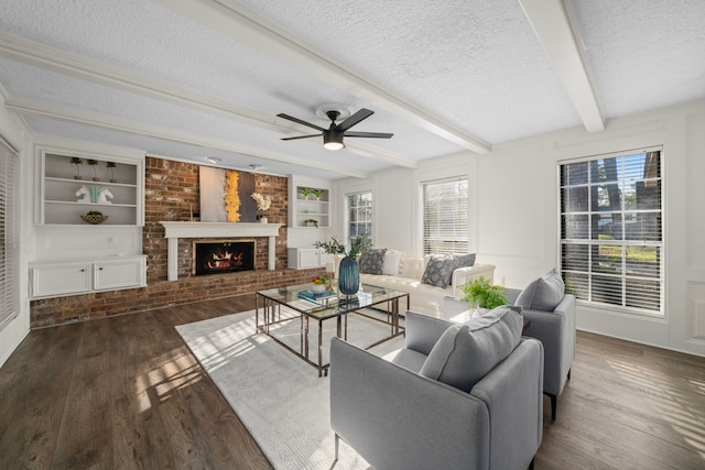 living room featuring beam ceiling, a fireplace, ceiling fan, and dark hardwood / wood-style flooring