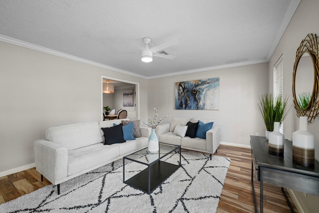 living room with hardwood / wood-style flooring, ceiling fan, crown molding, and a textured ceiling