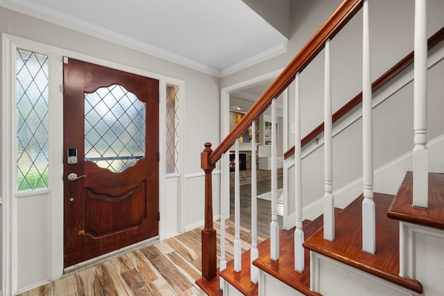 foyer entrance featuring wood-type flooring and ornamental molding