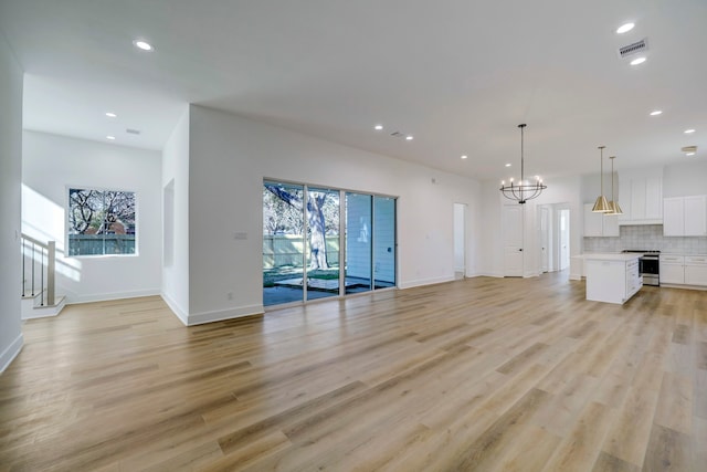 unfurnished living room featuring light hardwood / wood-style flooring and a notable chandelier