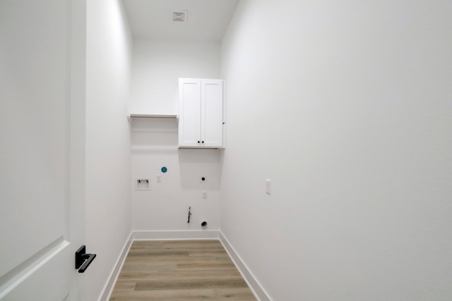 laundry area featuring light hardwood / wood-style floors, electric dryer hookup, cabinets, gas dryer hookup, and hookup for a washing machine