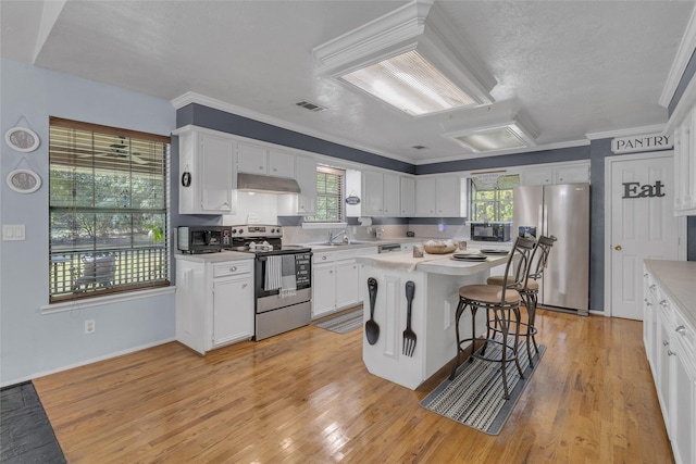 kitchen featuring sink, white cabinetry, a kitchen island, a breakfast bar area, and stainless steel appliances