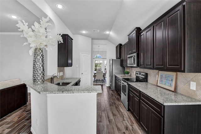 kitchen with sink, decorative backsplash, kitchen peninsula, and appliances with stainless steel finishes