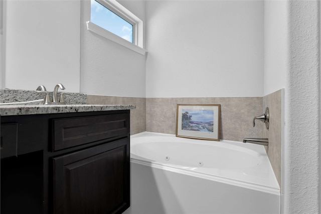 bathroom with vanity and a bath