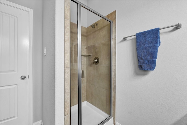 bathroom featuring a shower with door