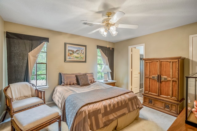 bedroom featuring multiple windows, a textured ceiling, and ceiling fan