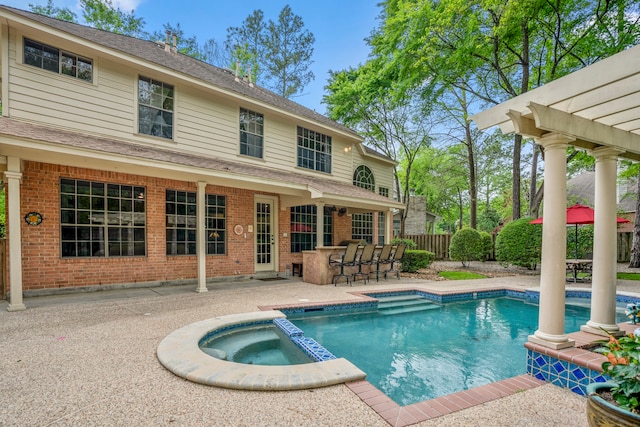 view of pool featuring a patio, an outdoor bar, an in ground hot tub, and a pergola