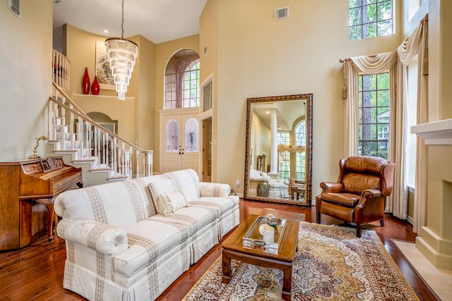 living room featuring a high ceiling, hardwood / wood-style floors, and a healthy amount of sunlight