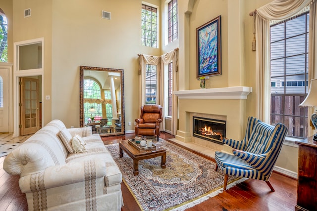 living area with a high ceiling and hardwood / wood-style floors