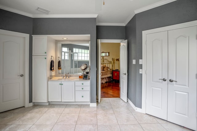 bathroom with tile patterned flooring, vanity, and crown molding