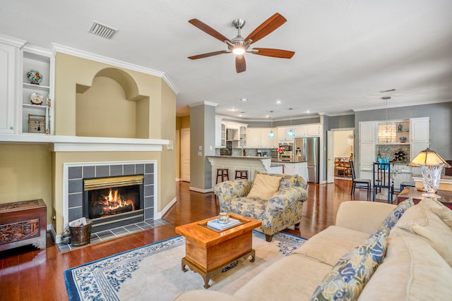 living room featuring a fireplace, dark wood-type flooring, and crown molding