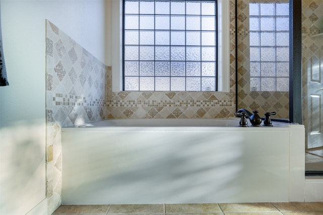 bathroom featuring plenty of natural light and a tub to relax in