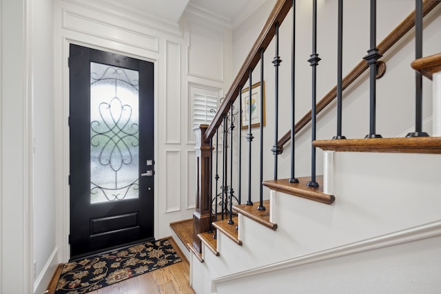 foyer featuring light hardwood / wood-style floors and ornamental molding