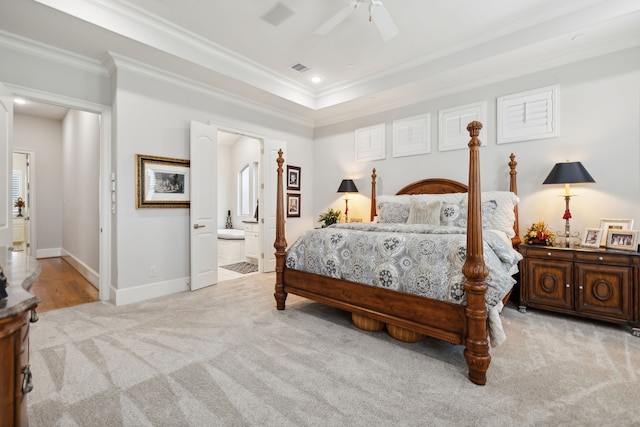 bedroom featuring ceiling fan, crown molding, light carpet, and ensuite bath