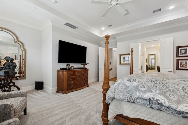 bedroom featuring a tray ceiling, ceiling fan, light colored carpet, and ornamental molding