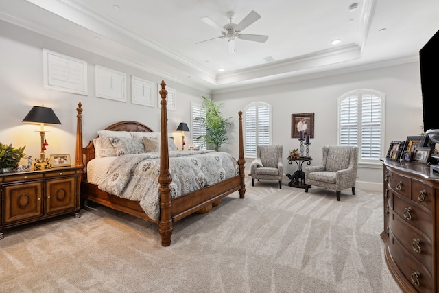 carpeted bedroom featuring a tray ceiling, ceiling fan, and ornamental molding