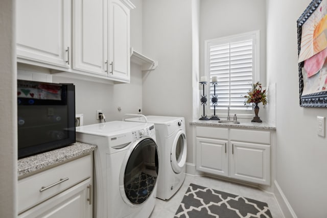 washroom featuring cabinets, separate washer and dryer, and sink