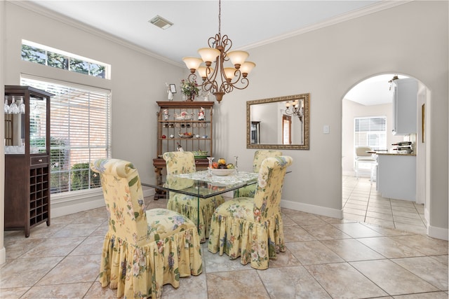 tiled dining space featuring crown molding and a chandelier