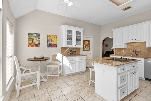 kitchen featuring black electric stovetop, a kitchen island, white cabinetry, and tasteful backsplash