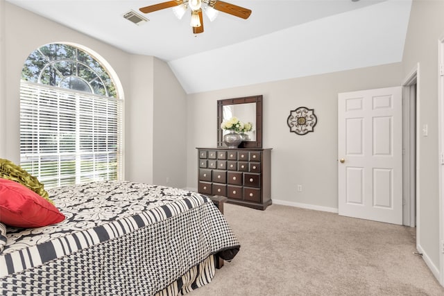 carpeted bedroom with ceiling fan and vaulted ceiling