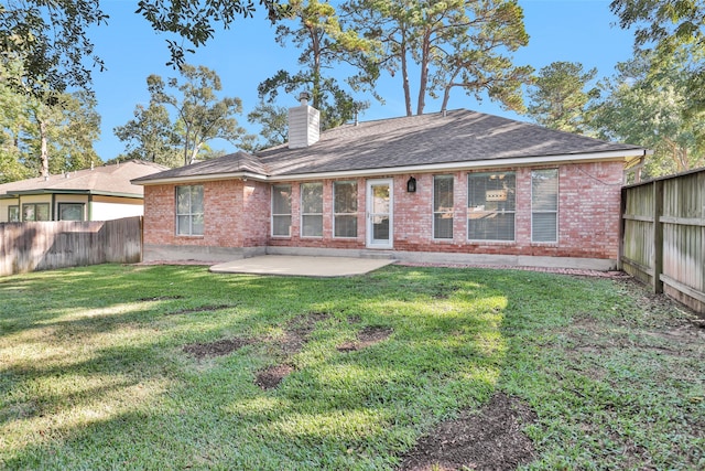 back of property with a yard and a patio