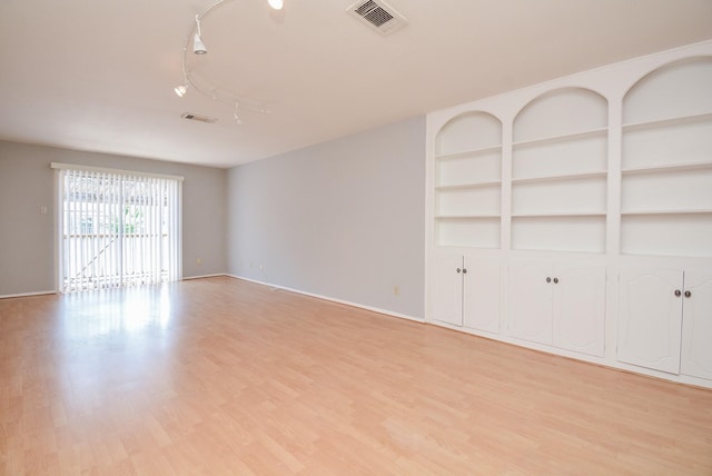 unfurnished living room with track lighting and light hardwood / wood-style flooring