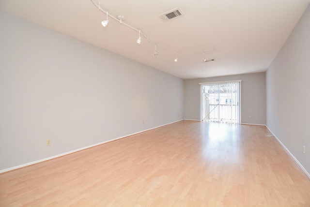 empty room featuring rail lighting and light wood-type flooring