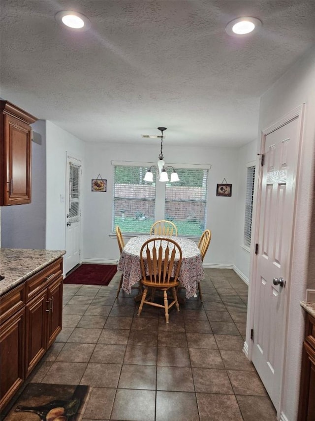 10438 Lauren Creek Dr, Baytown, TX 77523 - dining area featuring a textured ceiling, dark tile patterned floors, baseboards, recessed lighting, and a chandelier