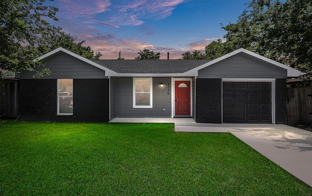 single story home with a garage and a yard