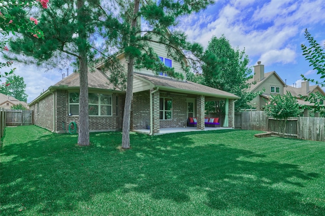 rear view of house with a patio and a yard