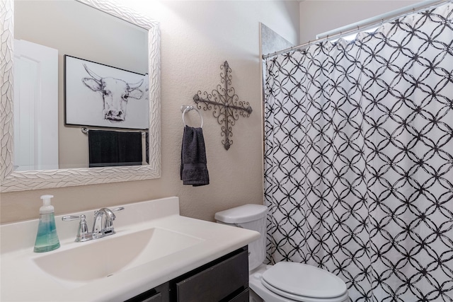 bathroom featuring vanity, curtained shower, and toilet