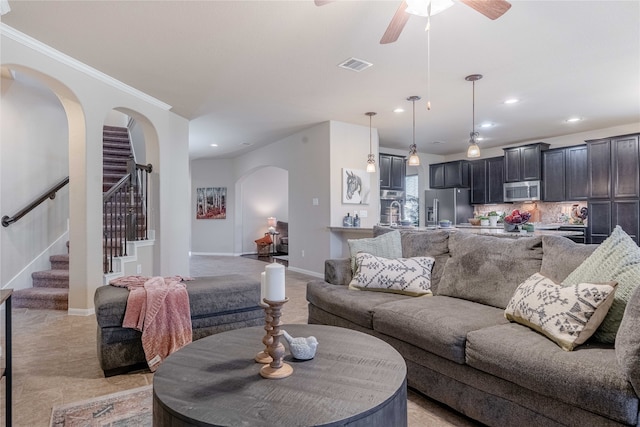 living room with ceiling fan and crown molding