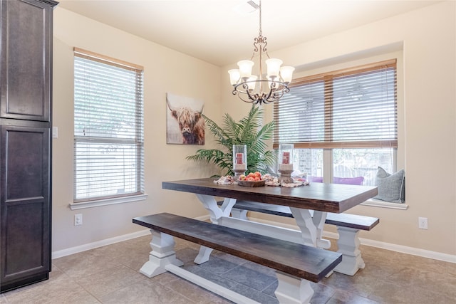 tiled dining space featuring an inviting chandelier and a healthy amount of sunlight