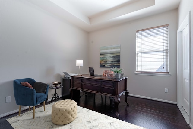 office featuring a tray ceiling and dark hardwood / wood-style floors