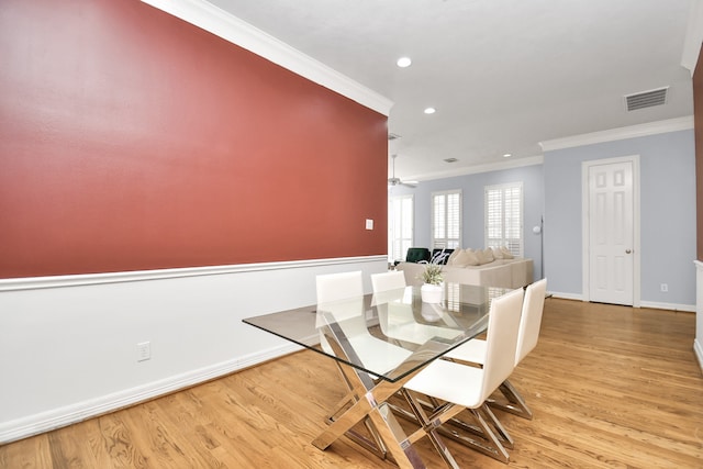 dining space with ceiling fan, ornamental molding, and light hardwood / wood-style flooring