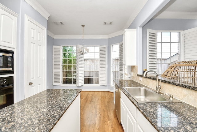 kitchen featuring appliances with stainless steel finishes, white cabinetry, a wealth of natural light, and sink