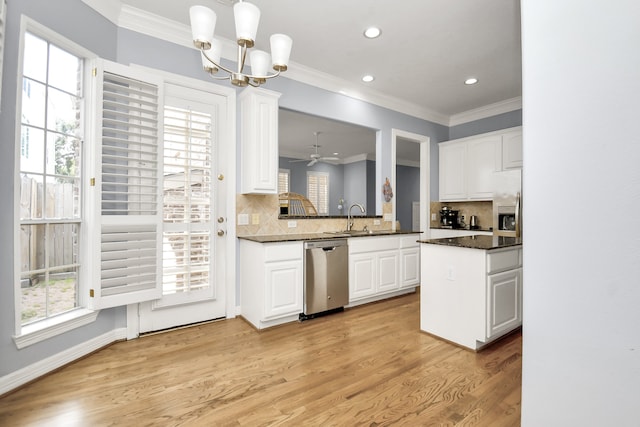 kitchen with stainless steel appliances, white cabinetry, hanging light fixtures, and light hardwood / wood-style floors