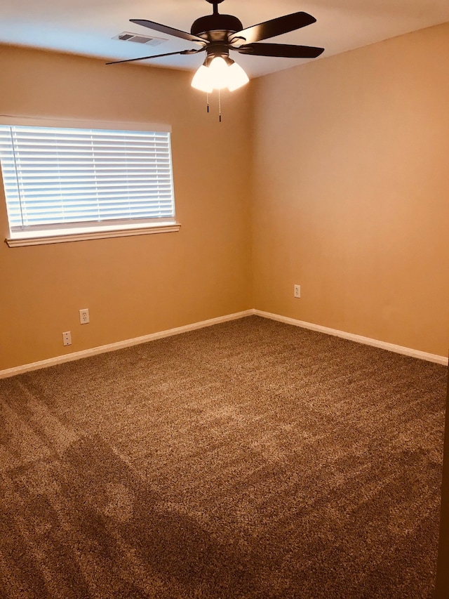 empty room with ceiling fan, a healthy amount of sunlight, and carpet floors