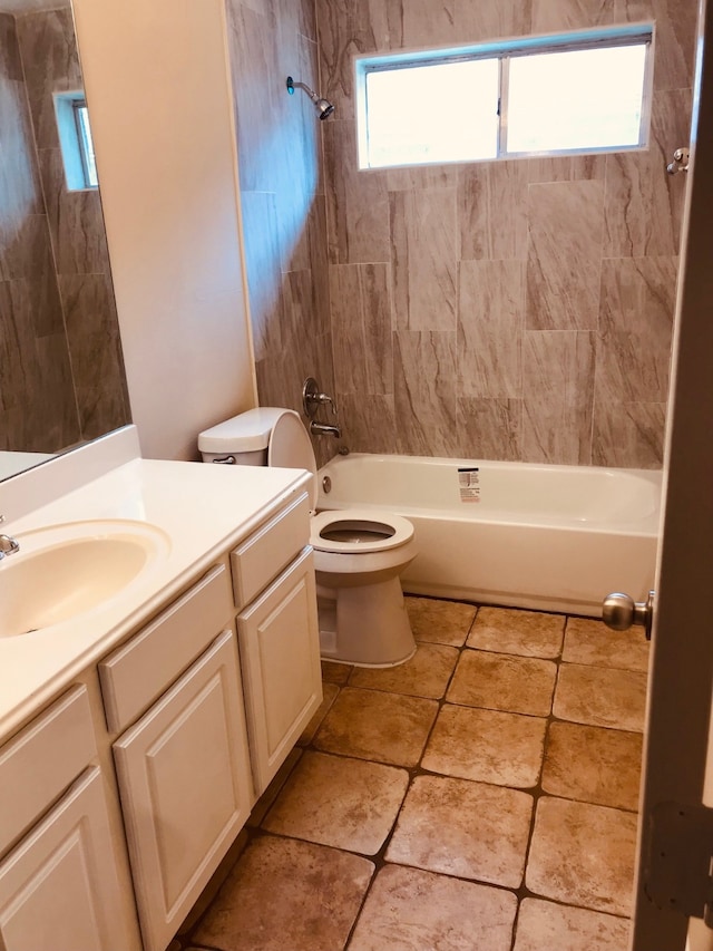 full bathroom featuring vanity, tiled shower / bath combo, and toilet