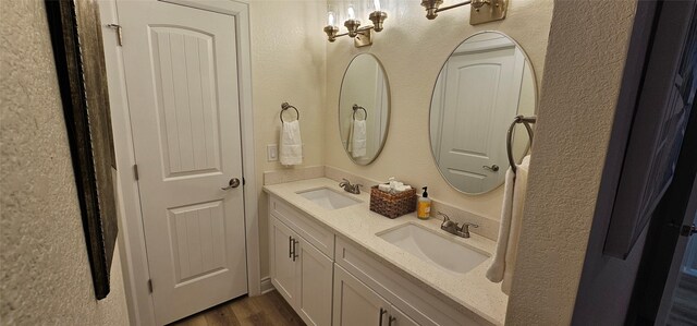 18103 Shaman Dr, Galveston, TX 77554 - full bathroom with double vanity and wood finished floors
